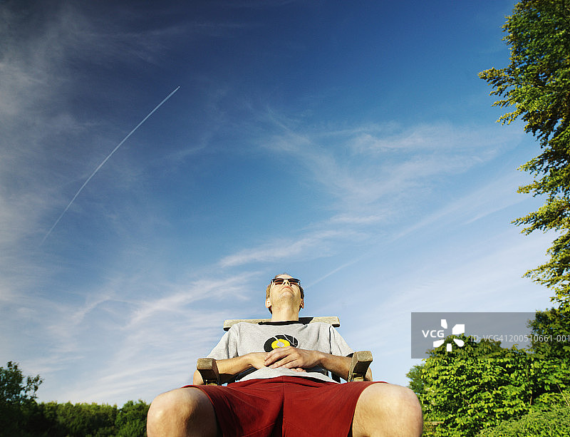 男人在花园的躺椅上放松图片素材