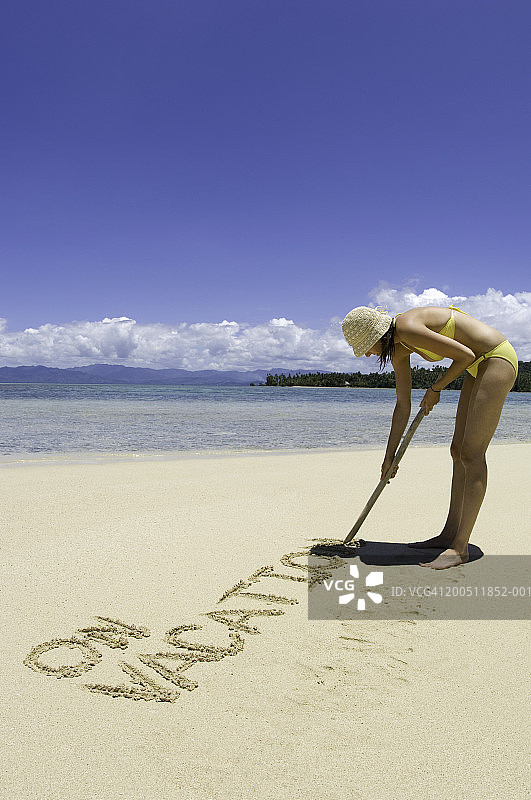 斐济瓦努阿岛，年轻女人沙滩写字图片素材