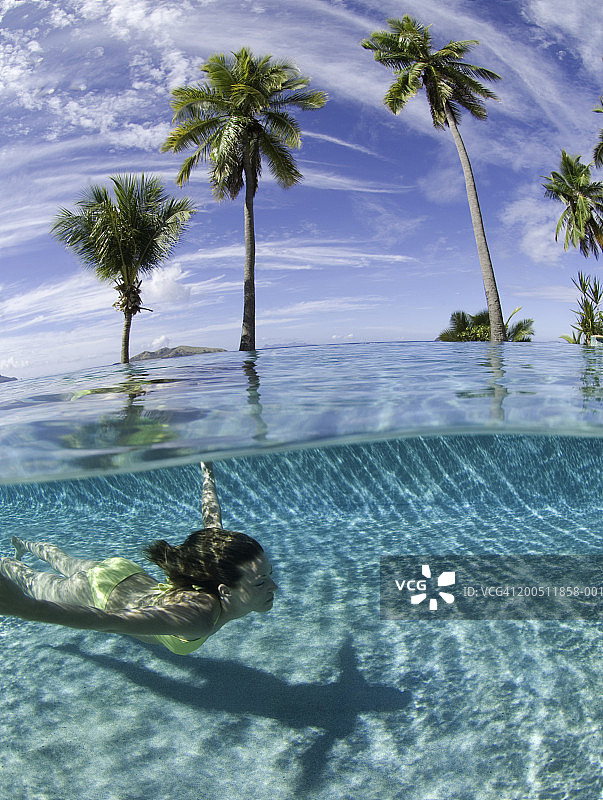 斐济：年轻女子在泳池游泳（水面视角）图片素材