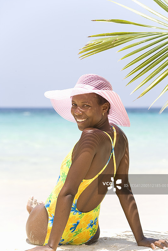海滩上回眸的年轻女子肖像图片素材