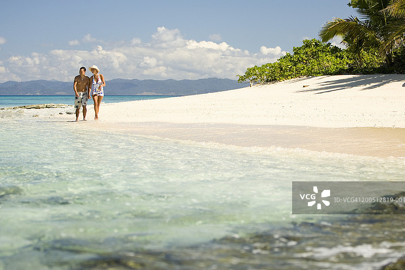 斐济贝卡岛，年轻男女在海滩上散步图片素材