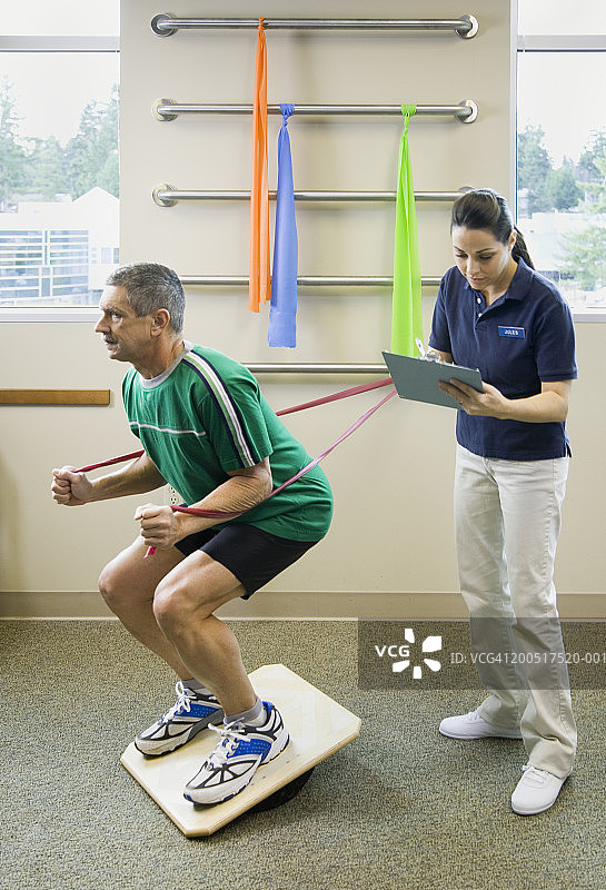 护士在物理治疗期间监测中年男人图片素材