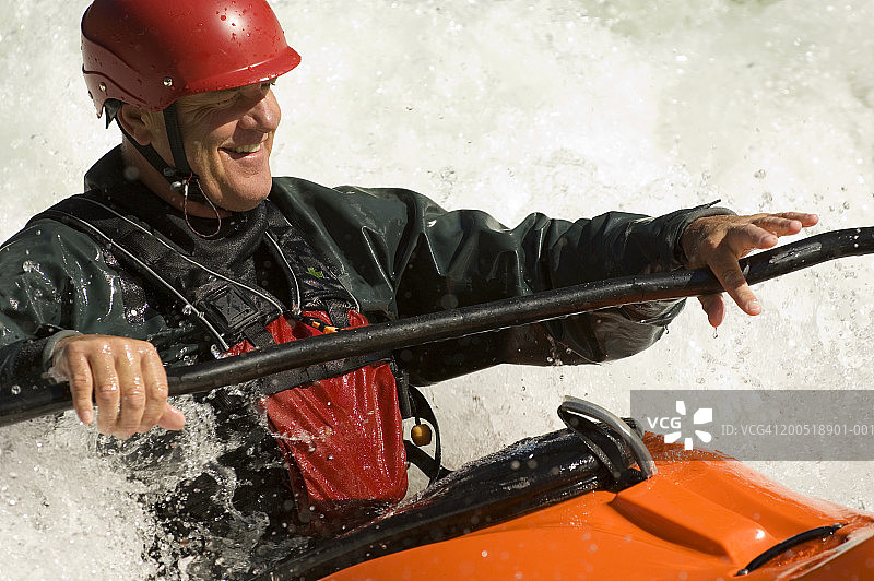 美国爱达荷州中年男人在三文鱼河中游划皮划艇图片素材
