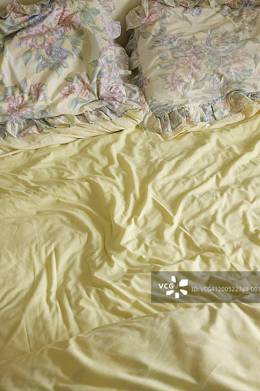 双人床上蓬松的枕头和被子图片素材