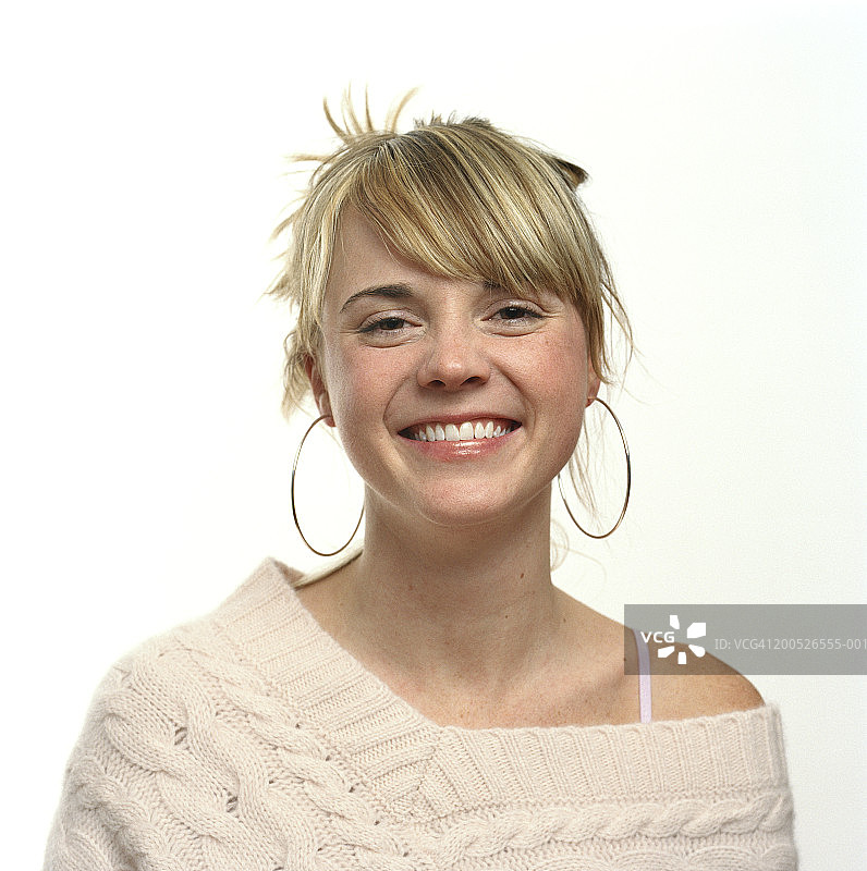 戴着耳环微笑的年轻女人特写图片素材