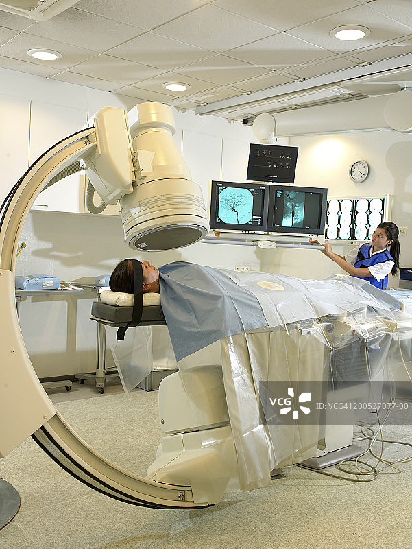 女患者在放射科接受女技师操作的机器检查图片素材