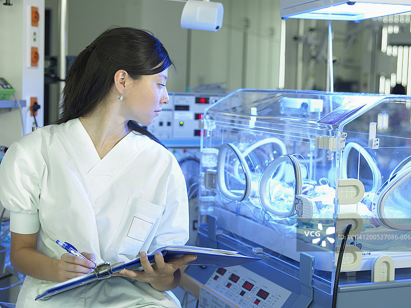 女护士在医院的保育箱中监测婴儿图片素材