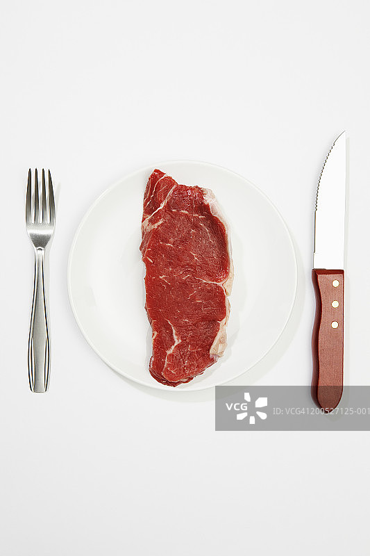刀叉餐盘中的生牛排，白色背景，顶视图图片素材