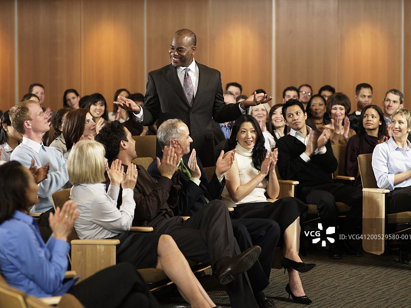 一群高管在礼堂为研讨会主持人鼓掌图片素材