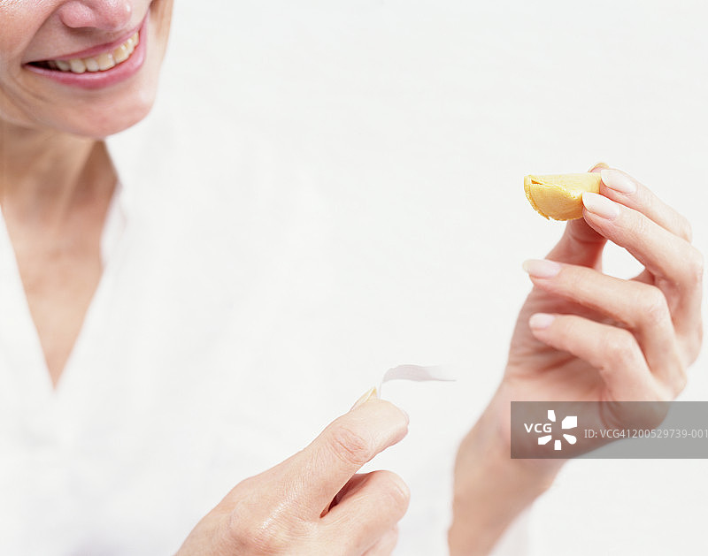 年长妇女打开幸运饼干，特写图片素材