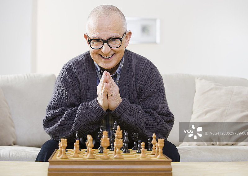 年长的男人坐在棋盘前微笑图片素材