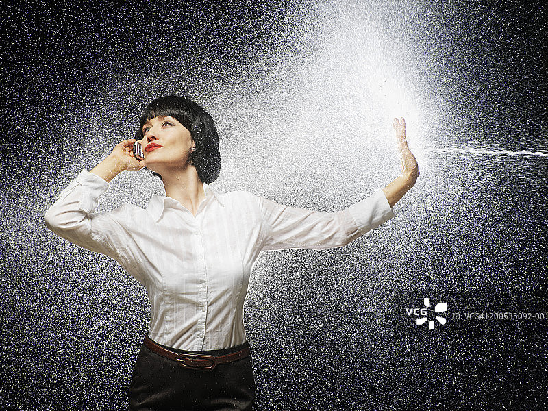被水泼到的使用手机的女商人图片素材