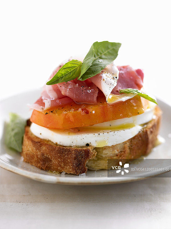 配马苏里拉奶酪、番茄、罗勒和意式火腿的开放式三明治图片素材