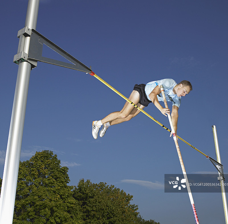 男人表演撑杆跳，低角度视角，户外图片素材