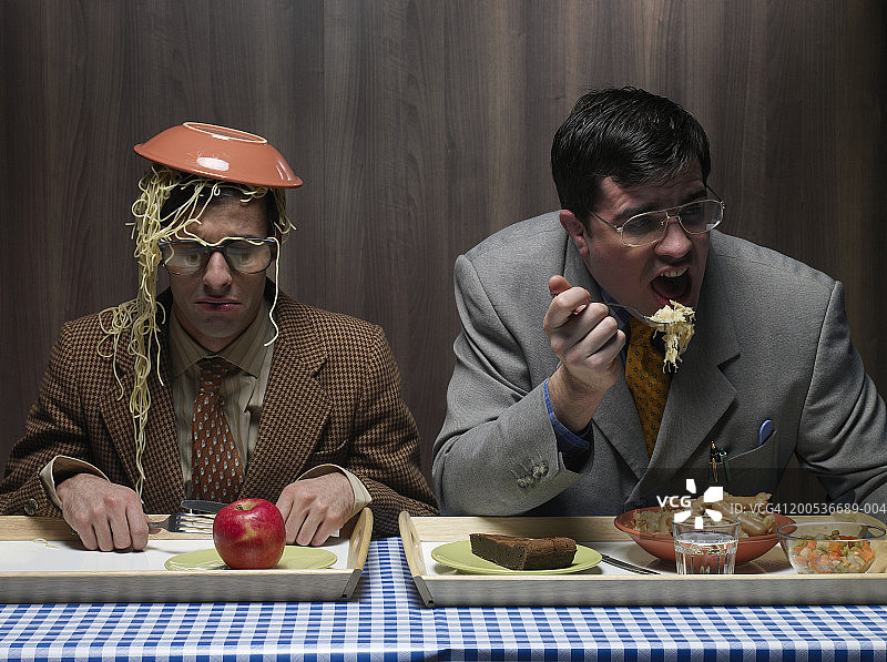 在食堂头顶着一碗意大利面的办公室职员和他的同事图片素材