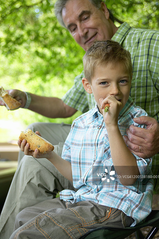 祖孙（6-8岁）在户外吃三明治图片素材