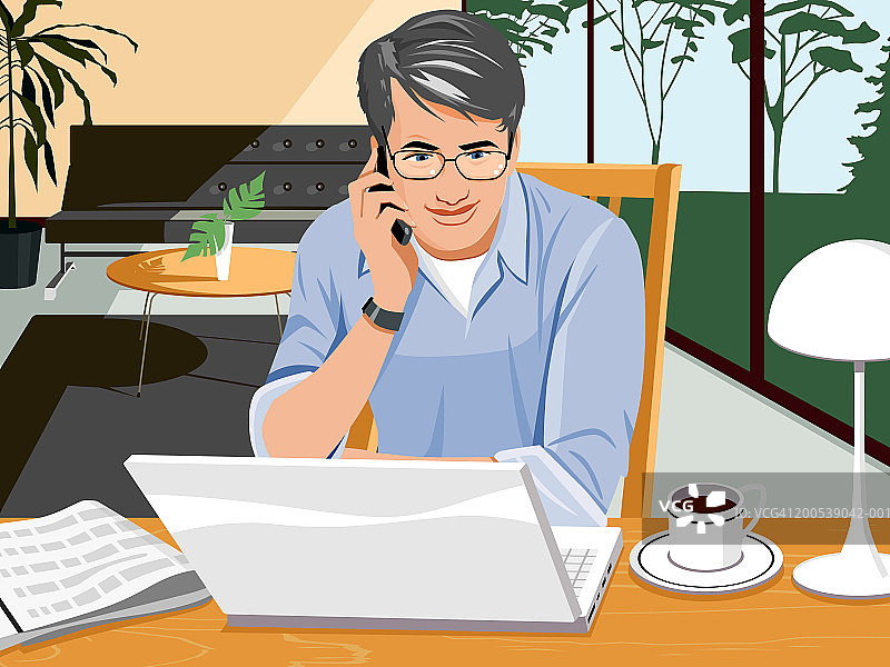 中年男人使用笔记本电脑并用手机通话图片素材