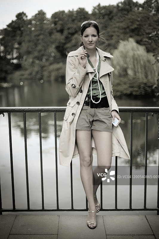 年轻女人倚靠在栏杆上吸烟肖像图片素材