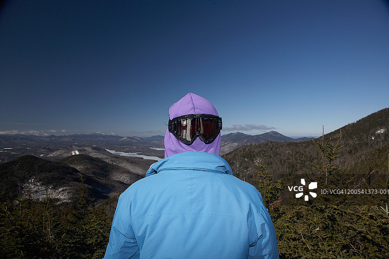 男子戴着太阳镜看山景，后视图图片素材