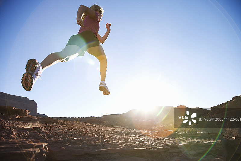 女人在岩石上奔跑，低角度视角图片素材