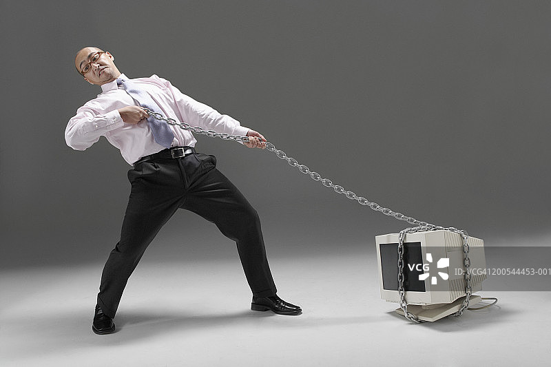 商务人士用链条拉着旧技术，工作室拍摄图片素材