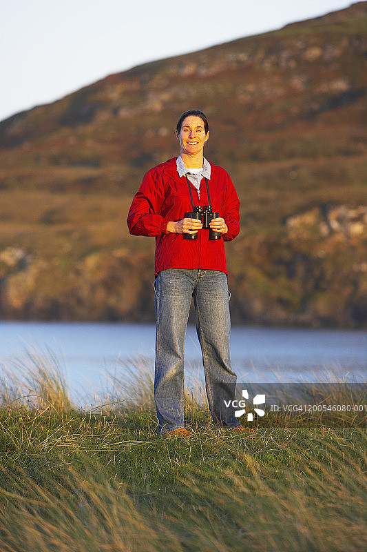 爱尔兰多尼戈尔巴利马斯托克海湾，手持望远镜的女人肖像图片素材