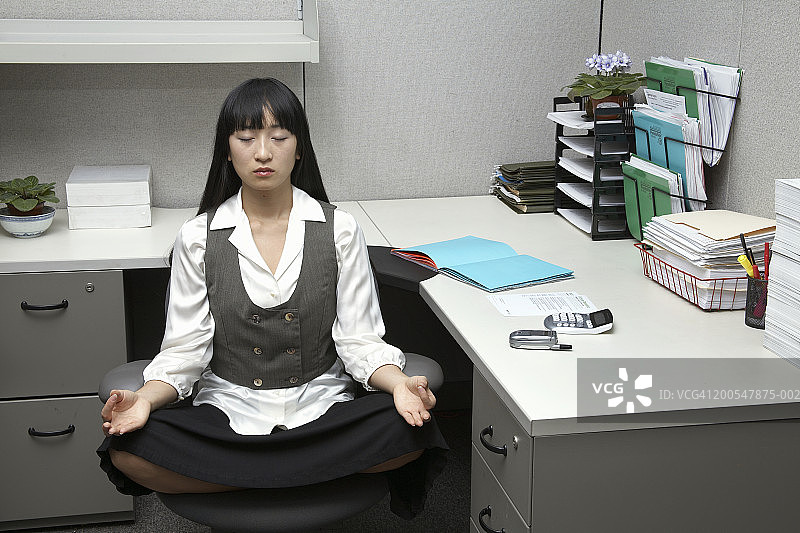 年轻女人在办公室椅子上冥想图片素材