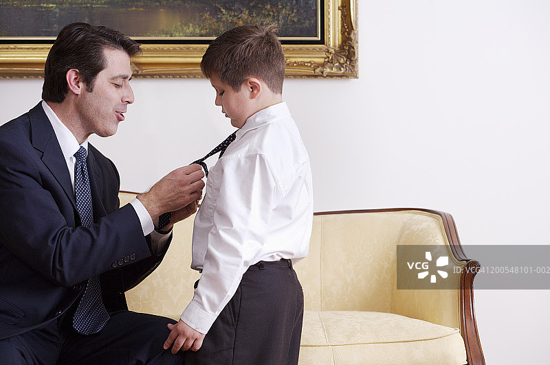 父亲为儿子整理领带（侧面）图片素材