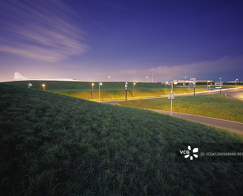 道路交叉路口与超音速飞机背景，黄昏图片素材