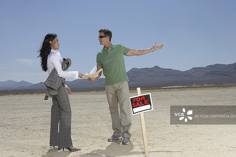 男人向女商人展示待售的干涸湖床图片素材
