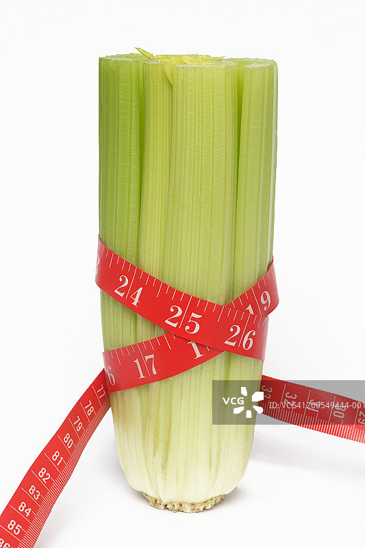 卷尺缠绕在芹菜心上，特写图片素材