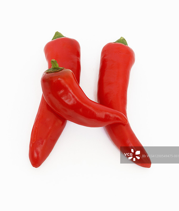 三个红色辣椒摆成字母“H”形特写图片素材