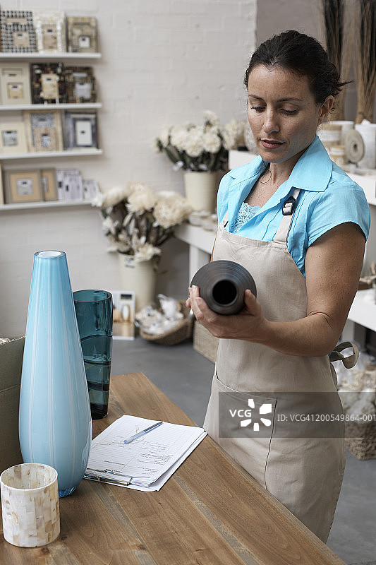 女店员在室内设计商店检查库存图片素材