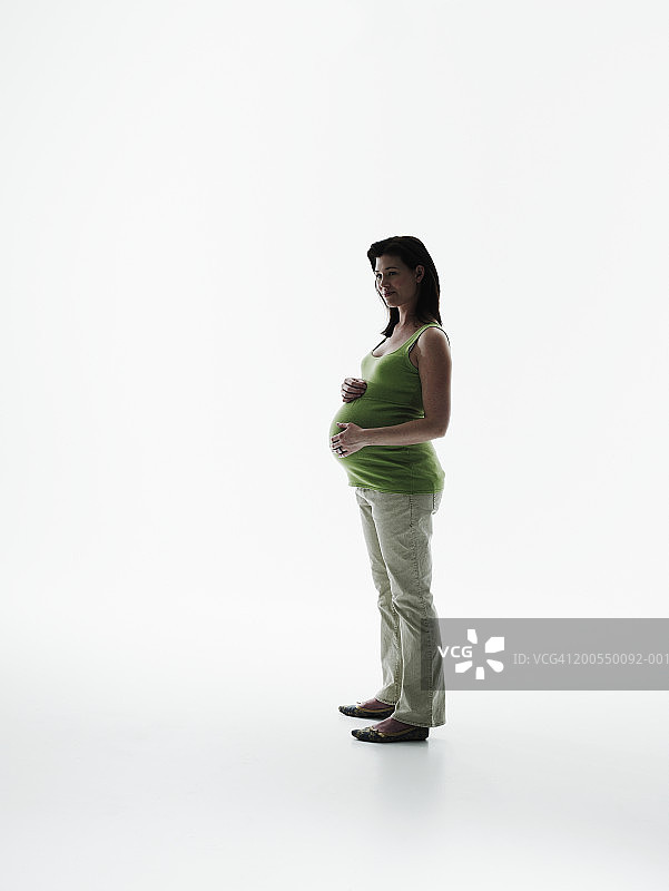 孕妇手扶肚子站立，侧视图图片素材