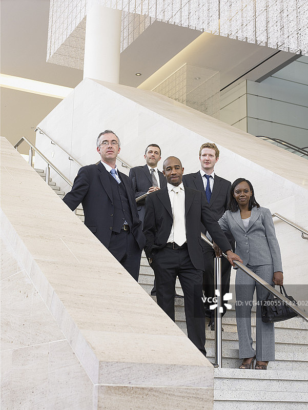 站在楼梯上微笑的商务人士（低角度人像）图片素材