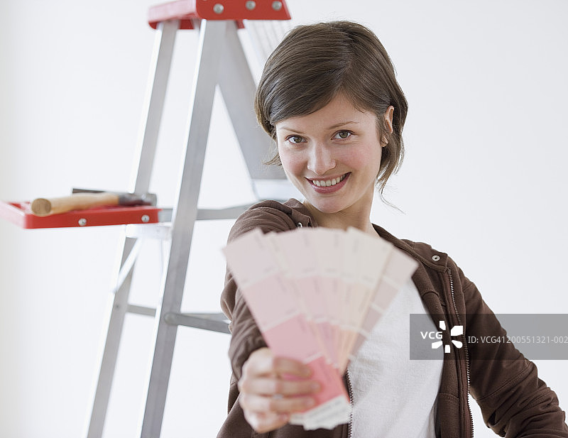 手持色卡样品的年轻女子肖像图片素材