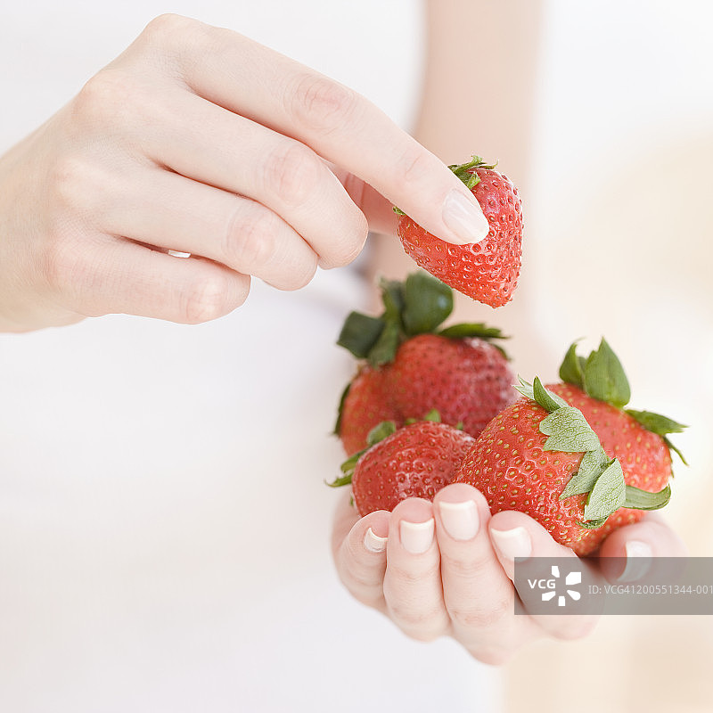 手持草莓的女人，特写，中部图片素材