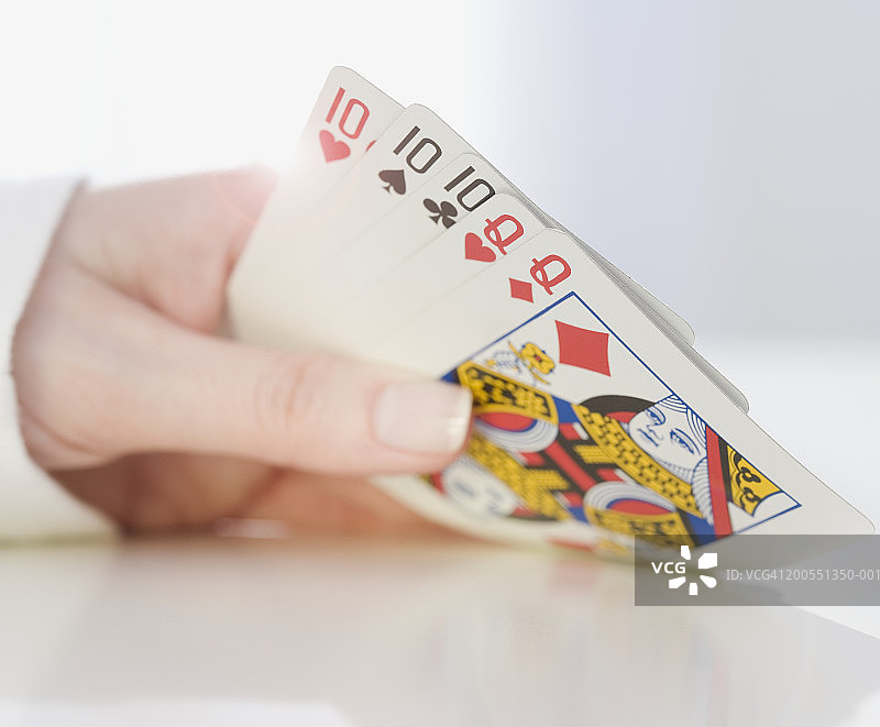 女人手拿扑克牌特写图片素材