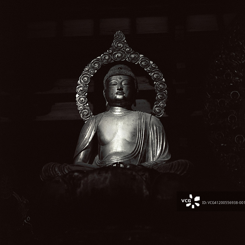 黑色背景上的银色佛像图片素材