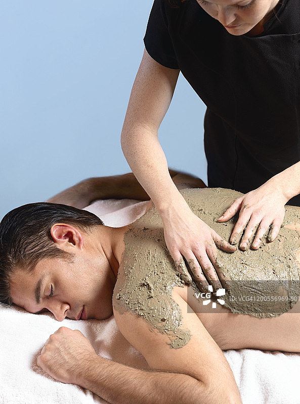男士接受女按摩师的泥浆按摩图片素材