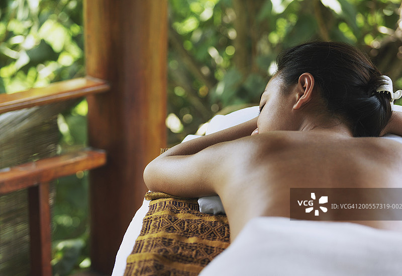 年轻女人躺在按摩床上图片素材