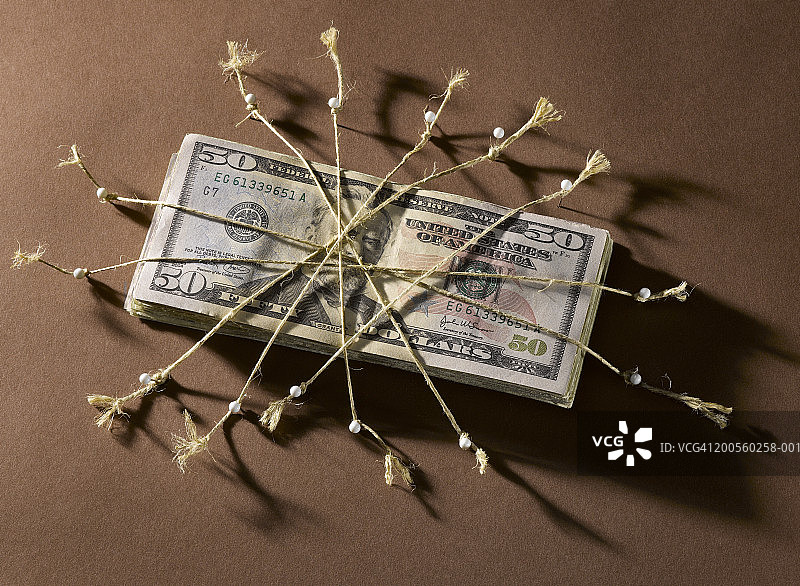 这是一堆用绳子和直别针绑着的美元，特写图片素材