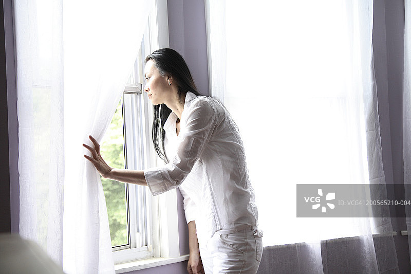 站在窗边微笑的女人肖像图片素材