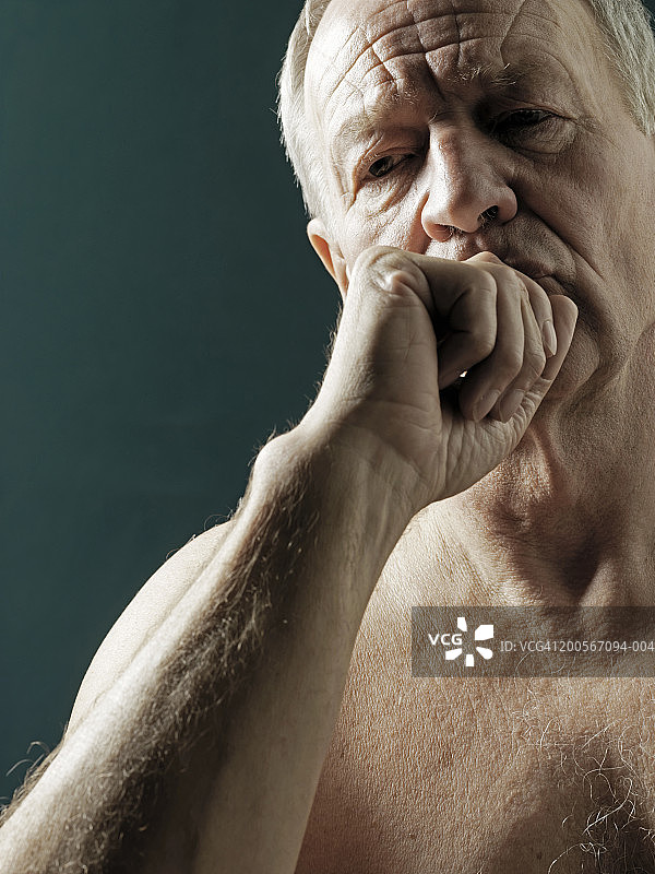 双手托腮的年长男人，绿色背景图片素材