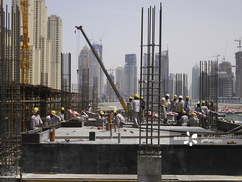 建筑工人在工地，背景是摩天大楼图片素材