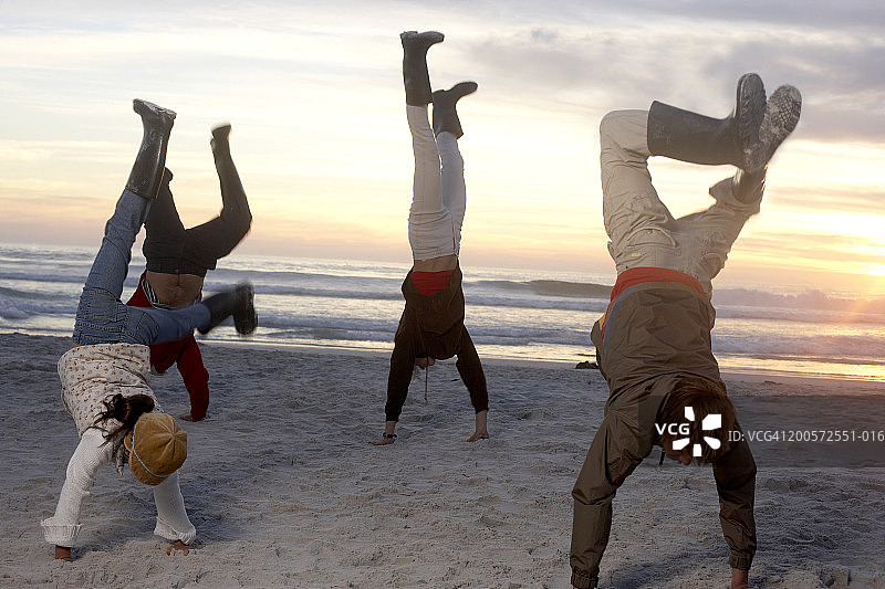 在海滩上做倒立的家庭图片素材