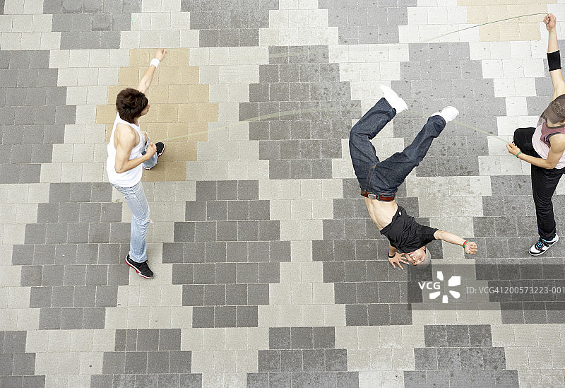 年轻男人玩跳绳游戏（高角度）图片素材