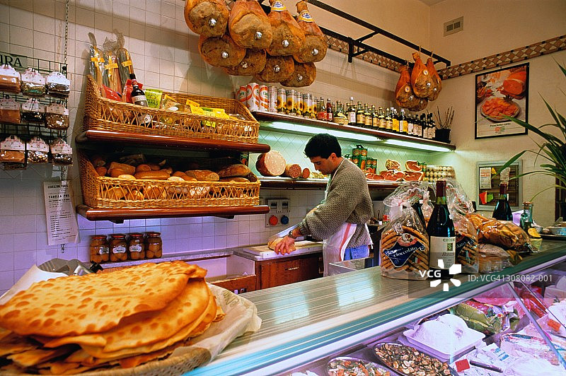 意大利佛罗伦萨：男子在熟食/面食店柜台后工作图片素材
