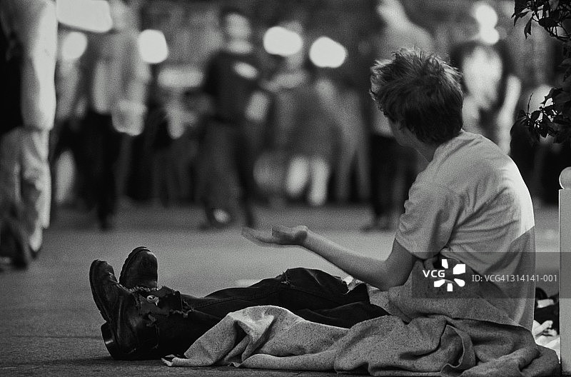 夜晚在街头乞讨的流浪者（黑白照片）图片素材