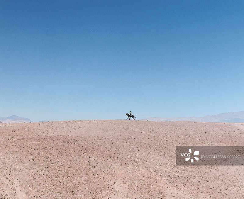 男子在地平线上骑马图片素材